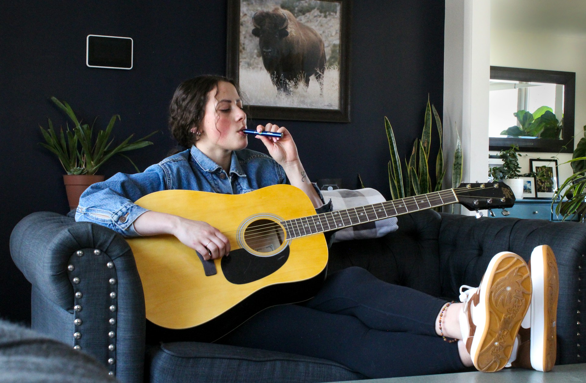 Woman holding a guitar while vaping