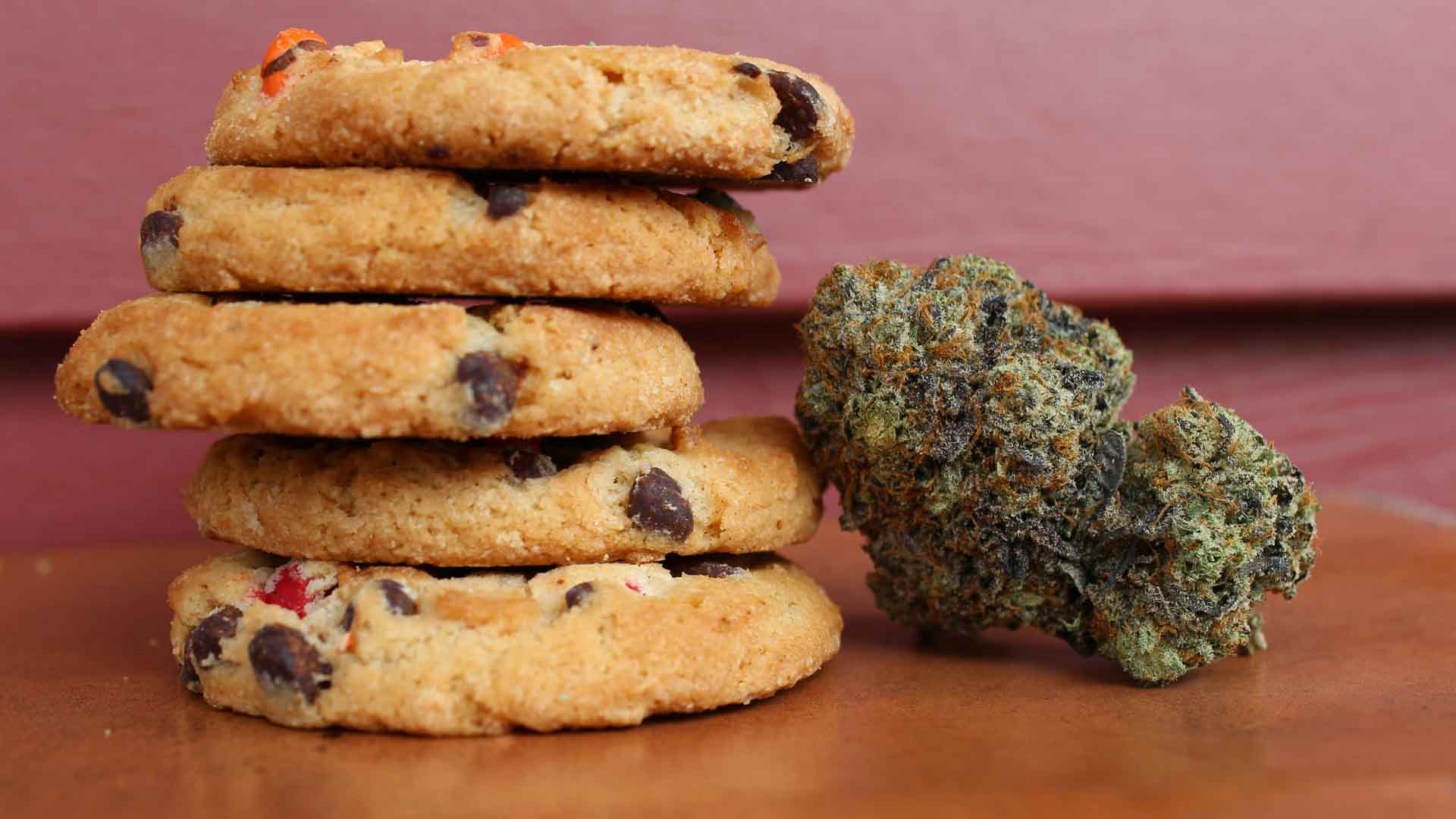 cannabis bud leaning against a stack of M&M cookies