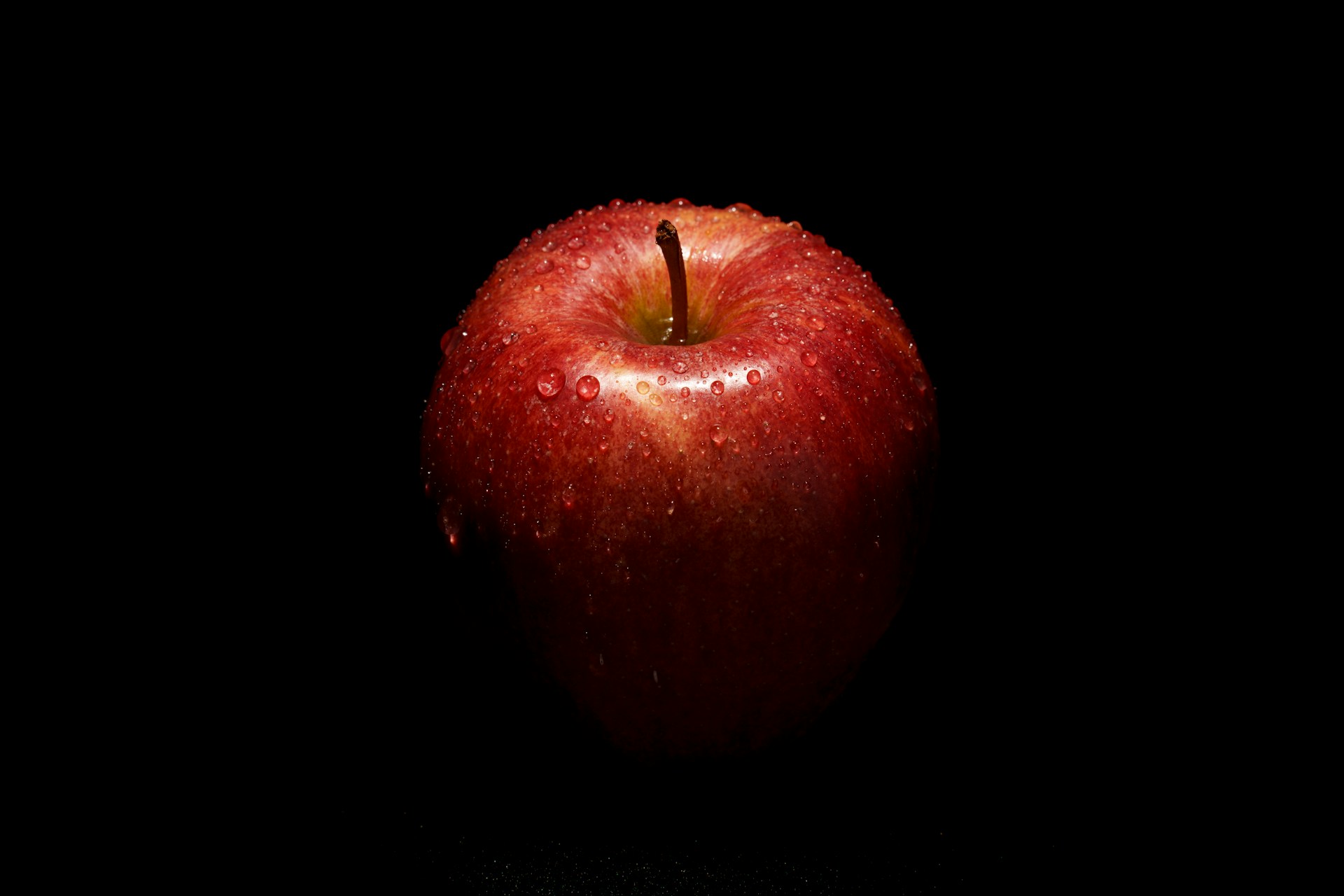 An apple sitting on a black table