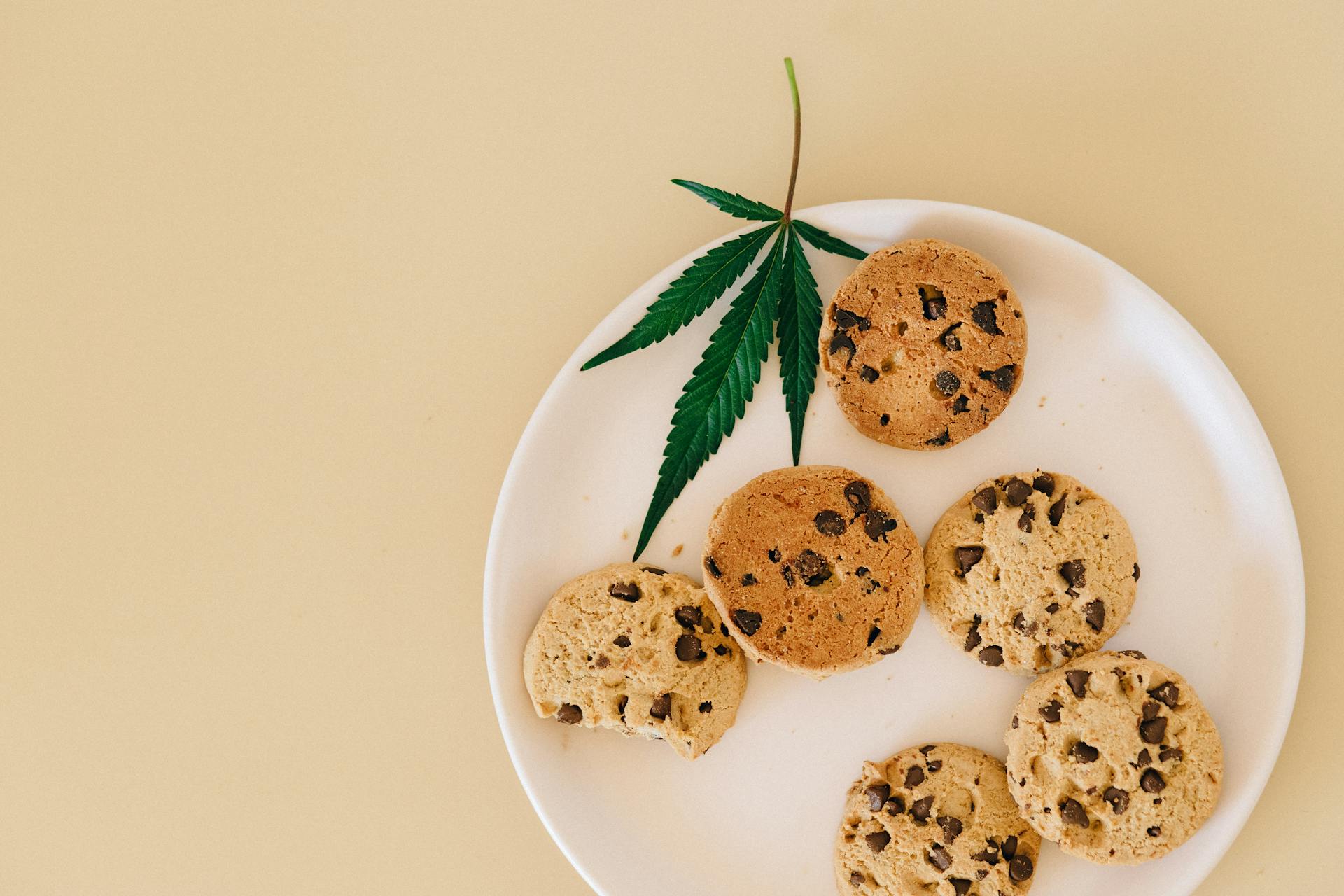 A plate of marijuana cookies next to a pot leaf