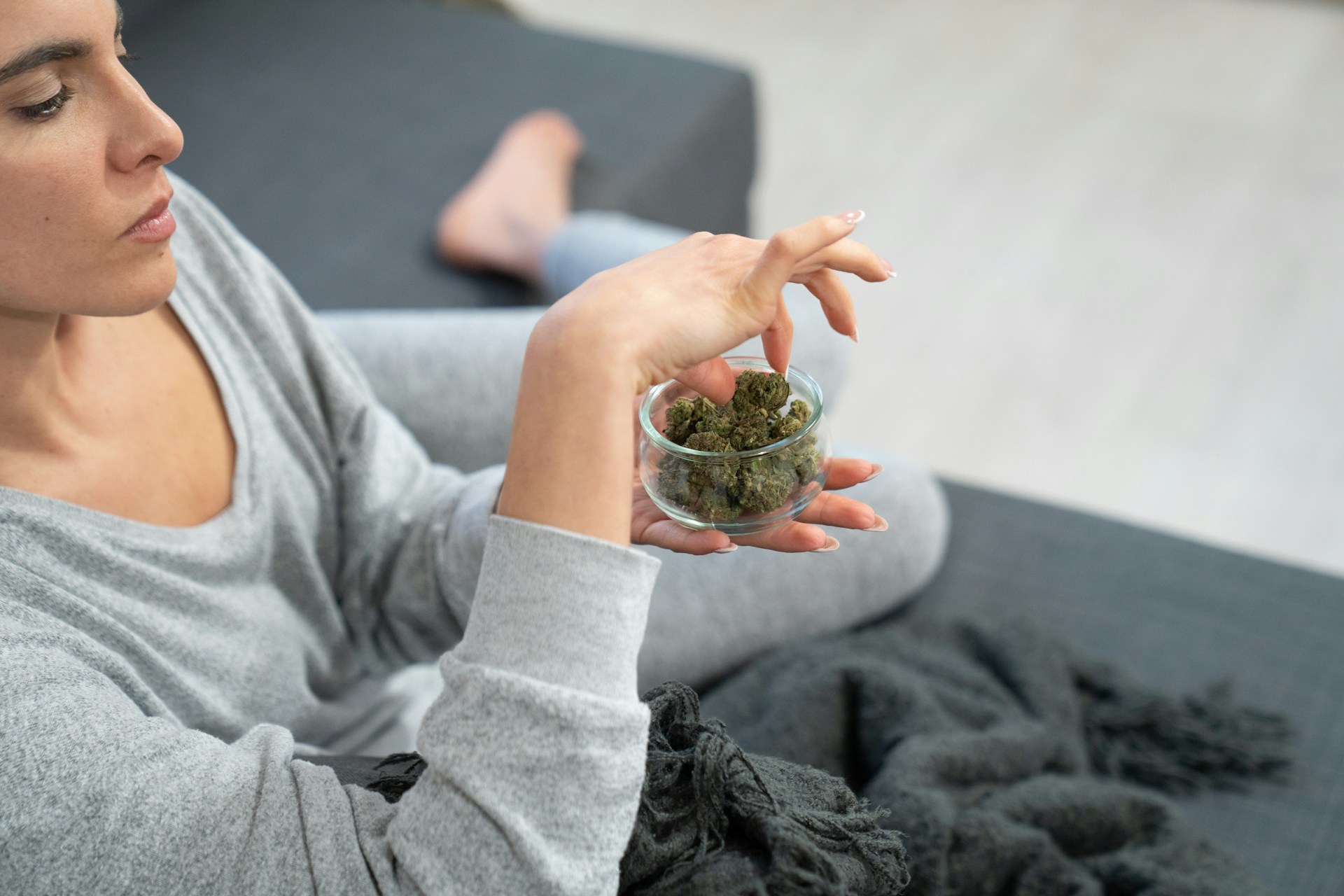 Woman grabbing cannabis out of candy dish